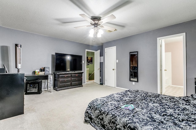 bedroom with a textured ceiling, carpet floors, ceiling fan, and connected bathroom