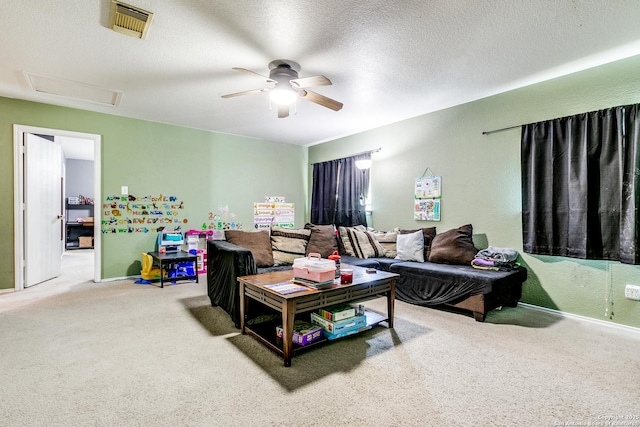 living room with ceiling fan, a textured ceiling, and carpet flooring