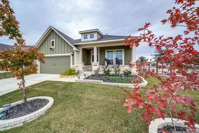 view of front facade featuring a porch, a front lawn, and a garage