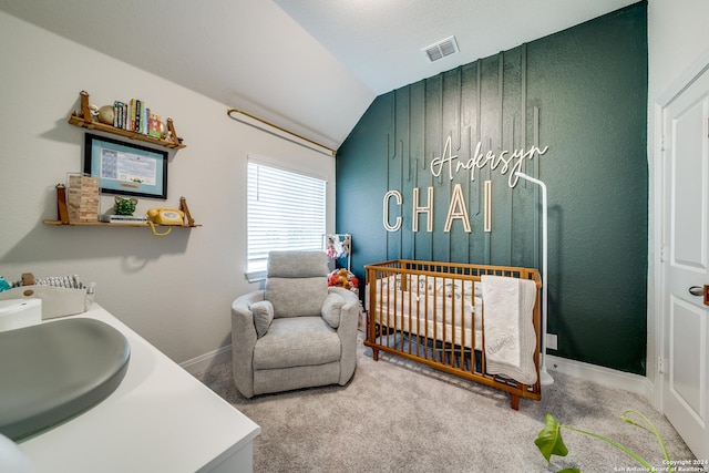 carpeted bedroom with sink, vaulted ceiling, and a crib