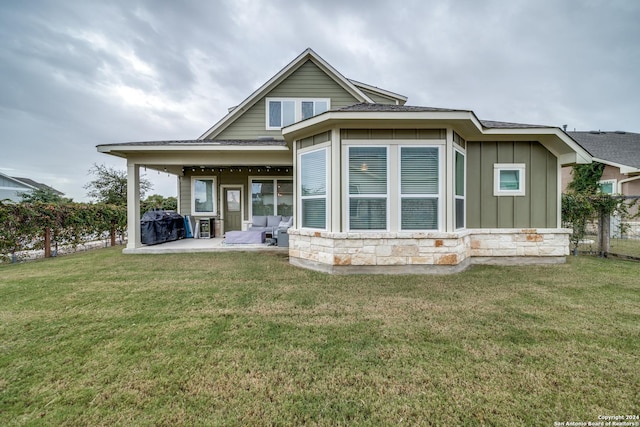 back of house featuring a patio and a lawn