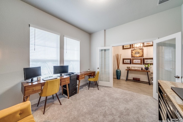 carpeted office featuring french doors