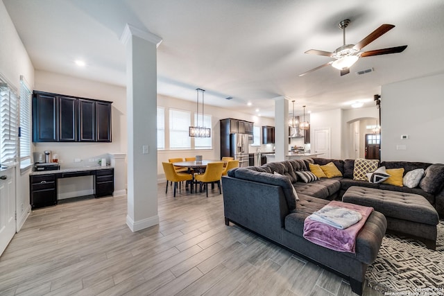 living room with ceiling fan with notable chandelier