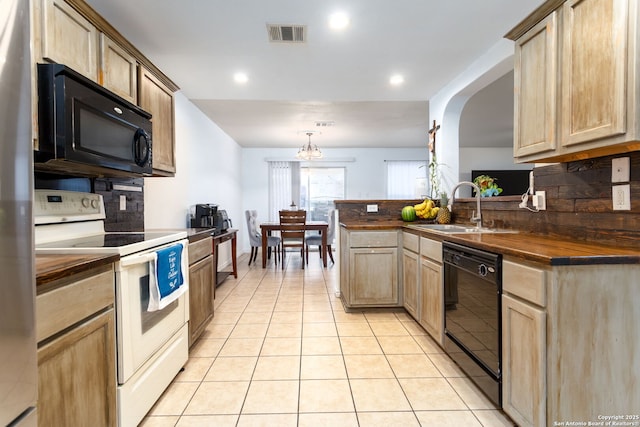 kitchen with sink, butcher block countertops, decorative backsplash, light brown cabinetry, and black appliances