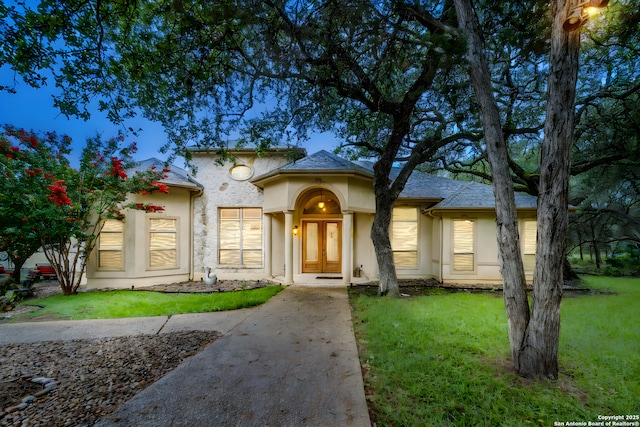 mediterranean / spanish-style home featuring french doors and a front yard