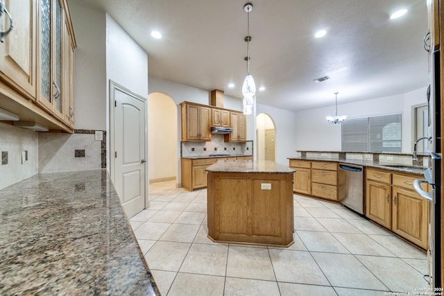 kitchen with dishwasher, pendant lighting, a center island, tasteful backsplash, and dark stone counters