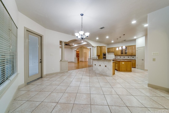 kitchen with ornate columns, a kitchen island, pendant lighting, and light tile patterned floors