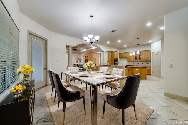 dining space with sink, light tile patterned flooring, and a chandelier