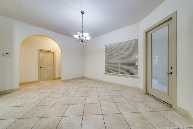 tiled empty room with a notable chandelier