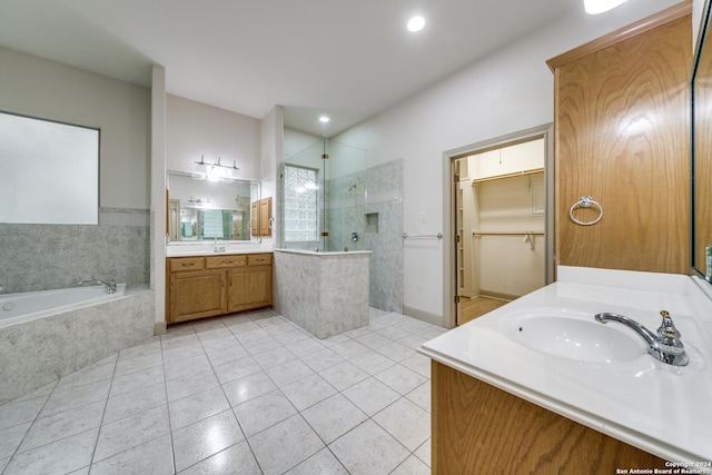 bathroom with tile patterned flooring, vanity, and shower with separate bathtub