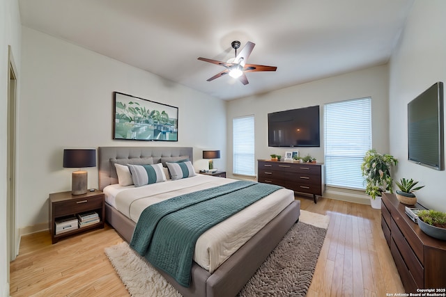 bedroom featuring multiple windows, light wood-type flooring, and ceiling fan