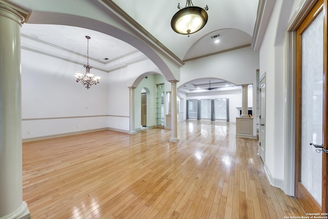 interior space featuring ornate columns, an inviting chandelier, ornamental molding, and light hardwood / wood-style flooring