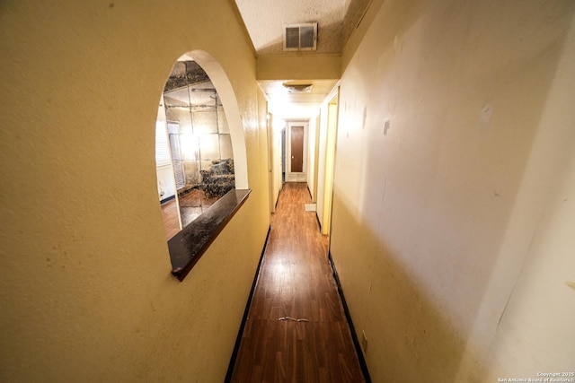 hall featuring a textured ceiling and wood-type flooring