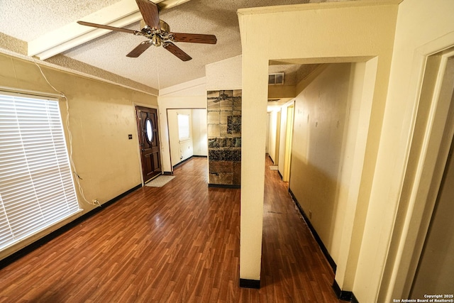 hallway featuring a textured ceiling, vaulted ceiling, and dark hardwood / wood-style floors