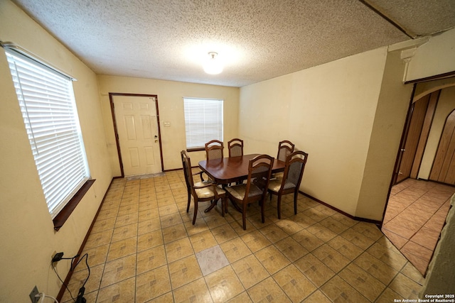 dining area featuring a textured ceiling and ornate columns