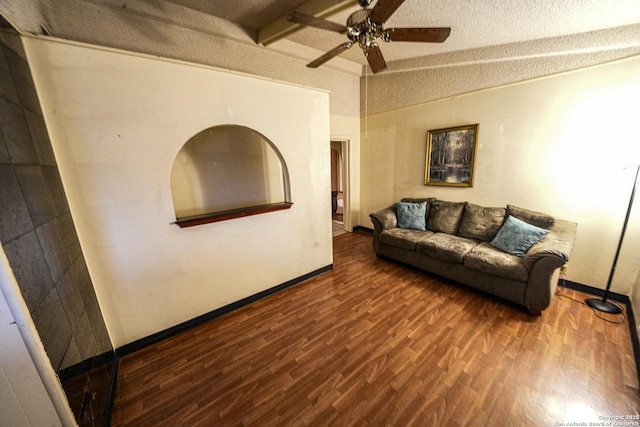 living room with a textured ceiling, ceiling fan, vaulted ceiling with beams, and dark hardwood / wood-style floors