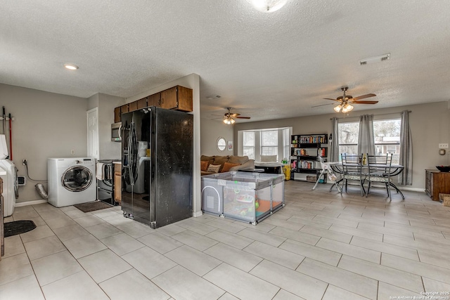 kitchen with black refrigerator with ice dispenser, a textured ceiling, washing machine and dryer, and ceiling fan