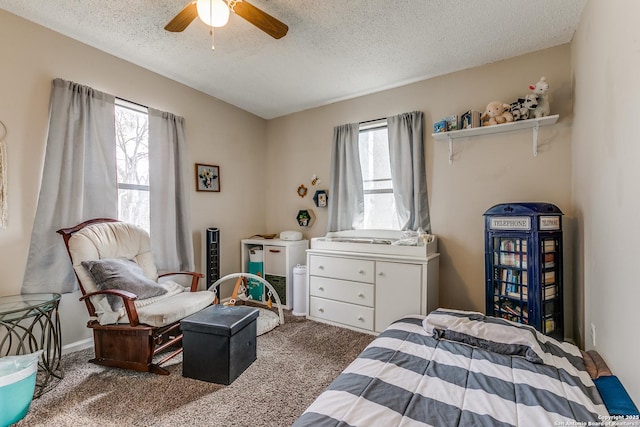 bedroom with a textured ceiling, carpet floors, ceiling fan, and multiple windows