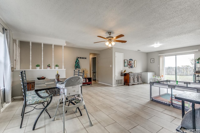 dining area featuring ceiling fan and a textured ceiling