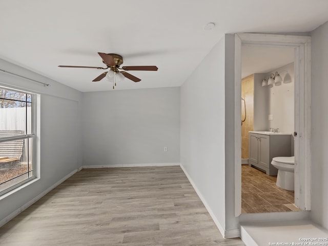 empty room featuring ceiling fan and light hardwood / wood-style flooring