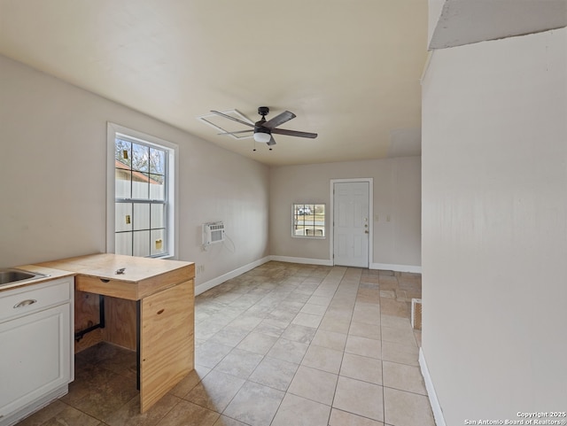 unfurnished office with ceiling fan, light tile patterned floors, and an AC wall unit