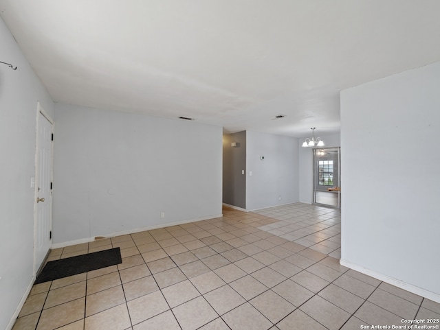 tiled empty room with a notable chandelier