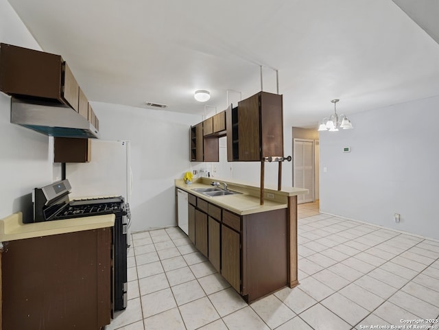 kitchen with stainless steel gas stove, a chandelier, light tile patterned floors, sink, and decorative light fixtures