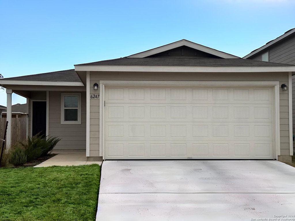 ranch-style home with a front lawn and a garage