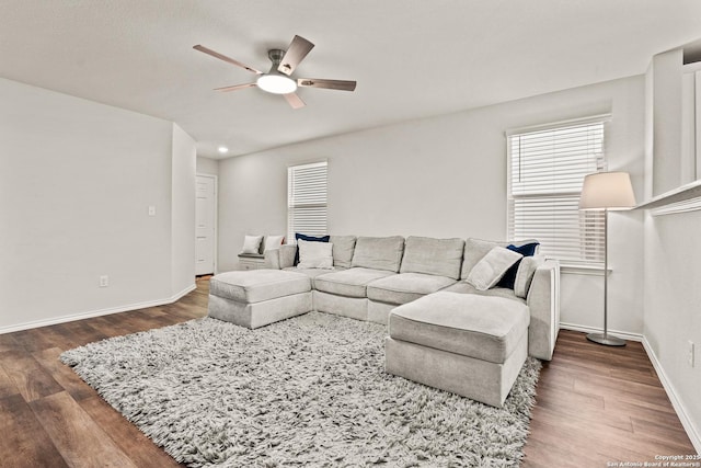 living room featuring ceiling fan and dark hardwood / wood-style flooring