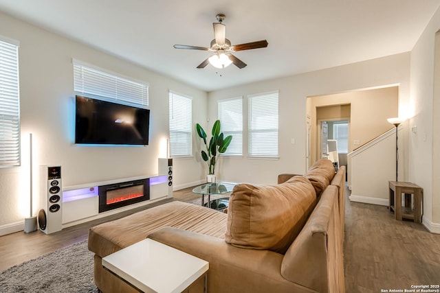 living room with wood-type flooring, ceiling fan, and a healthy amount of sunlight