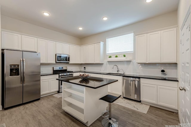 kitchen featuring a kitchen island, sink, appliances with stainless steel finishes, and white cabinetry