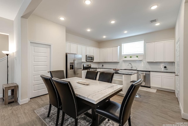 dining room featuring sink and light hardwood / wood-style flooring