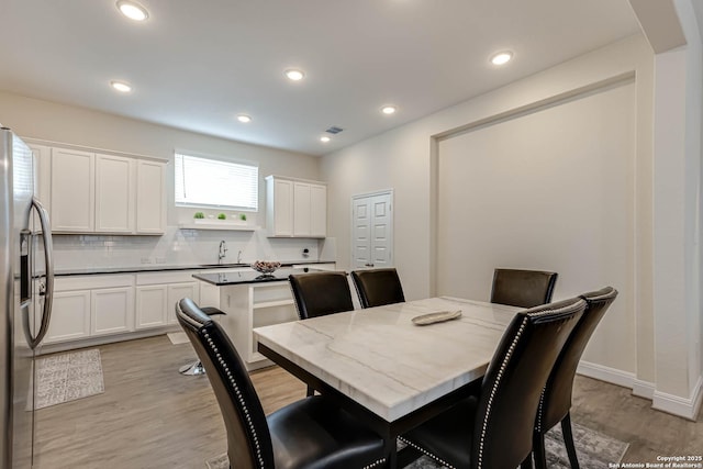 dining room with sink and light hardwood / wood-style floors