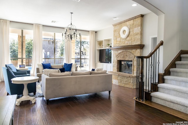 living area with dark wood finished floors, stairway, a fireplace, and visible vents