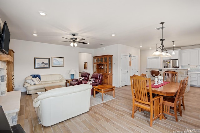 dining area with ceiling fan and light hardwood / wood-style floors