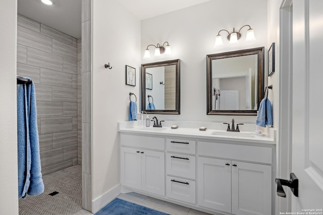 bathroom with tiled shower, tile patterned flooring, and vanity