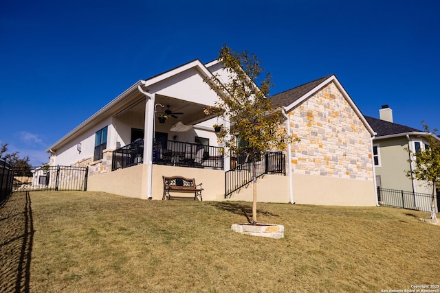 back of house featuring ceiling fan and a lawn