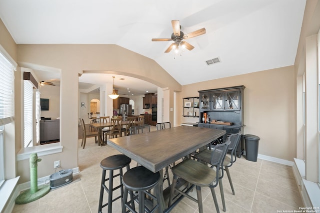 tiled dining space featuring lofted ceiling and ceiling fan