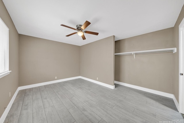 unfurnished bedroom featuring ceiling fan, light hardwood / wood-style flooring, a closet, and multiple windows