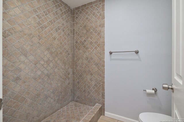 bathroom with tiled shower, tile patterned floors, and toilet