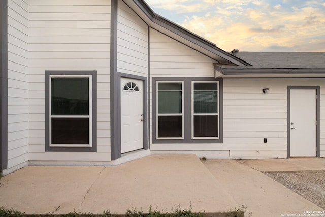 exterior entry at dusk featuring a patio