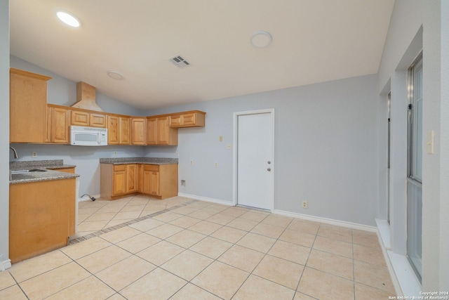 kitchen with vaulted ceiling, light tile patterned floors, and sink