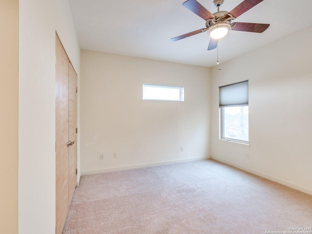 carpeted spare room with ceiling fan