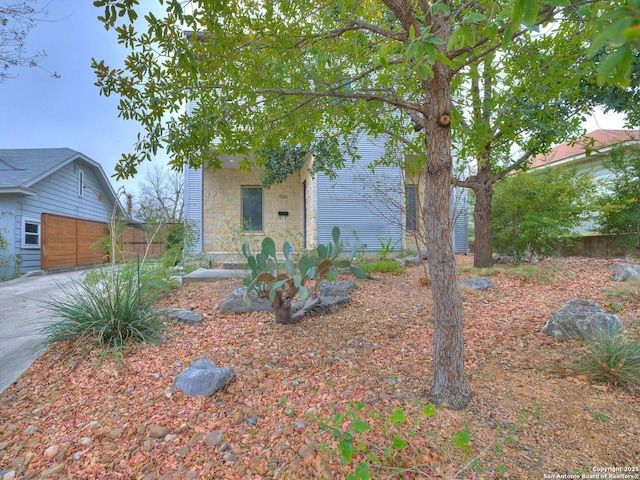 view of property hidden behind natural elements featuring a garage