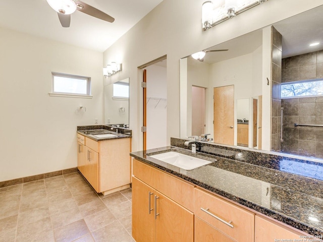 bathroom with tile patterned floors, ceiling fan, tiled shower, and vanity