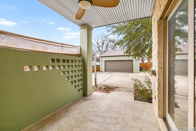 view of patio with a garage, an outdoor structure, and ceiling fan