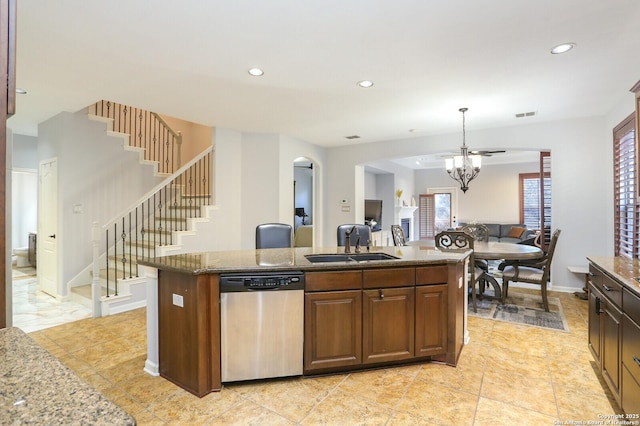 kitchen with sink, a center island, dishwasher, a notable chandelier, and light stone countertops