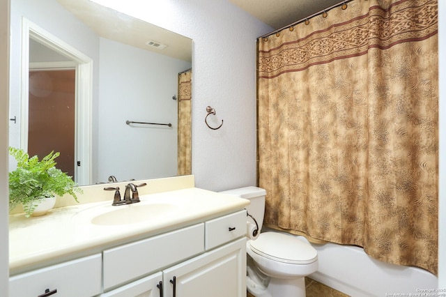 full bathroom featuring vanity, shower / bath combo with shower curtain, and toilet