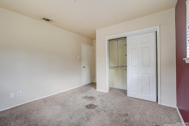 unfurnished bedroom featuring light carpet and a closet