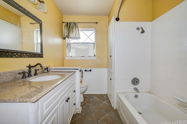 full bathroom with toilet, tile patterned floors, tiled shower / bath, and vanity